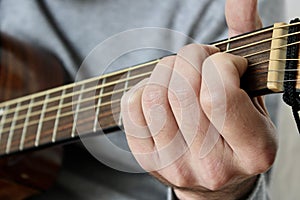 Hand Playing an E Chord on a Guitar