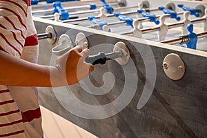 Hand playing foosball. People enjoying table soccer game