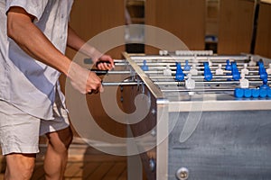 Hand playing foosball. People enjoying table soccer game