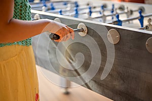 Hand playing foosball. People enjoying table soccer game