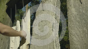 Hand plays on sounding stones. Shorted stones hung on string like musical drumming tool.