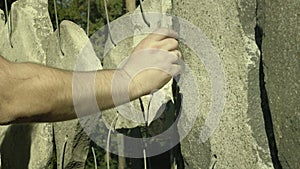 Hand plays on sounding stones. Shorted stones hung on string like musical drumming tool.