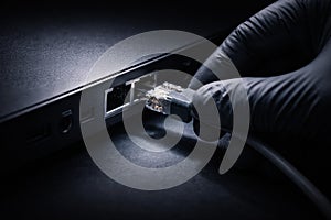 Hand plugging ethernet cable into network port