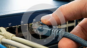 Hand Plugging Ethernet Cable into Network Switch Port