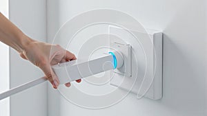 Hand Plugging In a White Plug