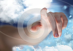 Hand pointing against cloudy sky in background