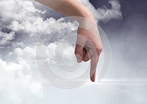 Hand pointing against digitally generated Clouds