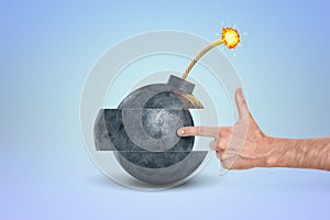 Hand pointing at a cartoon bomb with fuse