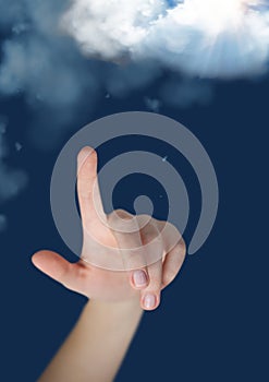 Hand pointing clouds against digitally generated background