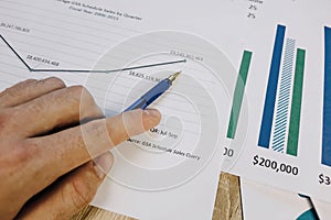 hand pointing financial charts on the table