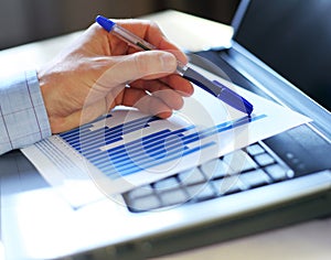 Hand pointing on a graph data. Selective focus