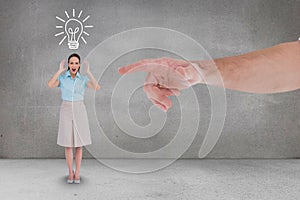 Hand pointing at happy business woman against grey background with a bulb icon