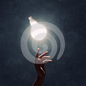 Hand pointing light bulb