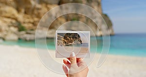 Hand, polaroid and beach for photography, vacation and memories for travel scrapbook. Female tourist, ocean background