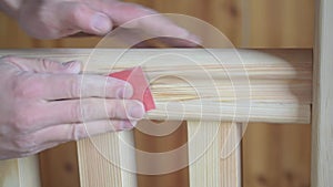 Hand polishing wooden hand rail with sandpaper