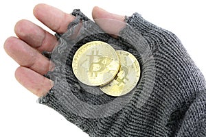 Hand of the poor with broken glove with two bitcoin coins