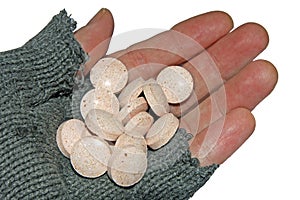 Hand of poor man holding a handful of tablets