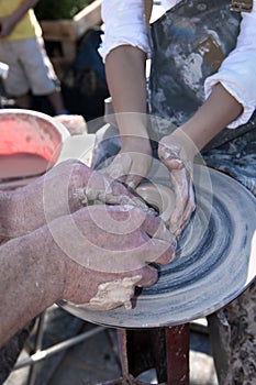 Hand of the potter and the child in the creation