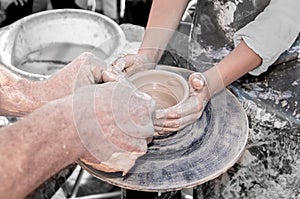 Hand of the potter and the child in the creation