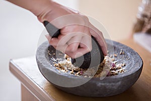 Hand pounding herbs on a traditional pounder