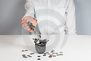 Hand pour coins falling out in wallet