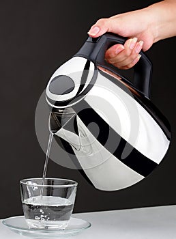 Hand pouring chrome kettle water boiler isolated