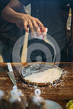 Hand pouring condense milk in Mutabbak or matabbak, also mutabbaq, is a stuffed pancake or pan-fried bread. This is Chocolate and