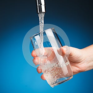 Hand pouring a glass of drinking water