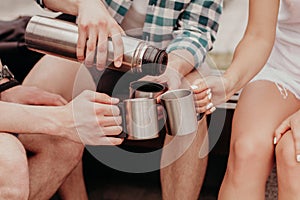 Hand Is Pouring Tea From The Thermos Into Three Mugs.