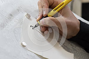 hand practices decorating letters from a Torah scroll written on parchment in Hebrew