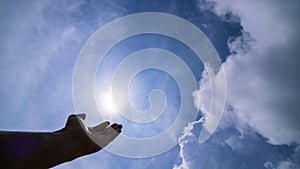 Hand praying for blessing from god on sun and clouds background,Christian Religion concept photo