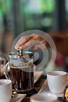 Hand preparing coffee in French Press Coffee Maker. Morning concept. coffee siphon. Spent coffee break at the organic cafe and pre