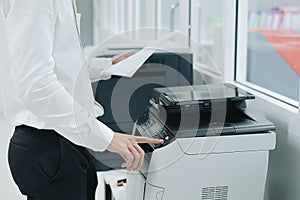 Hand press button on panel of printer scanner or laser copy machine in office