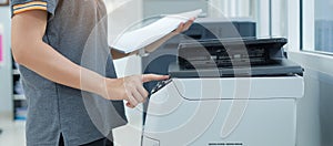 Hand press button on panel of printer scanner or laser copy machine in office