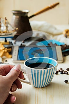 Hand press smart phone with coffee cup and earphone,concept everything can do on your hand by smart phone,top view