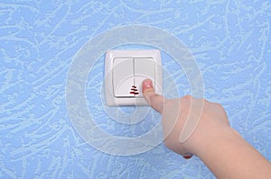 Hand pressed to switch on the wall