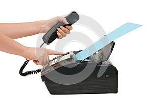 The hand presses the fax button