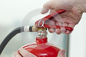 Hand presses the trigger fire extinguisher