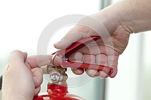 Hand presses the trigger fire extinguisher