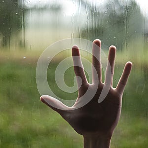 Hand pressing against window