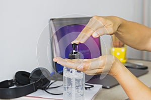 Hand pressing alcohol gel before usine laptop prevent spreading coronavirus, work from home concept. photo