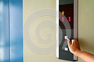 Hand pressing the button of elevator with key for self-sanitization