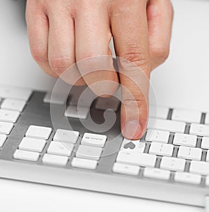 hand pressing button with heart on white keyboard