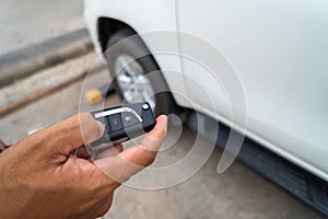 Hand pressing the button on the remote to lock or unlock the car