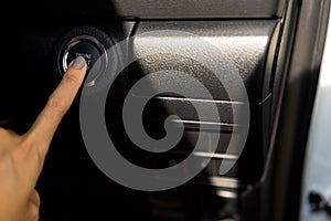 Hand pressing the button to start engine the modern car