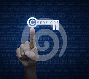 Hand pressing copyright key icon over computer binary code blue