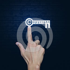 Hand pressing copyright key icon over computer binary code blue