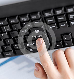 hand pressing donation button on keyboard