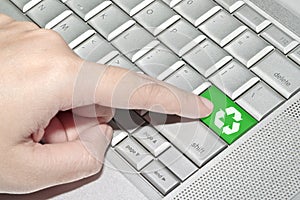 Hand pressing on green recycle sign button