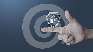 Hand pressing house with shield icon over light gradient blue background, Business home insurance and security concept